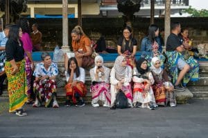 A group of people sitting on a bench next to each other