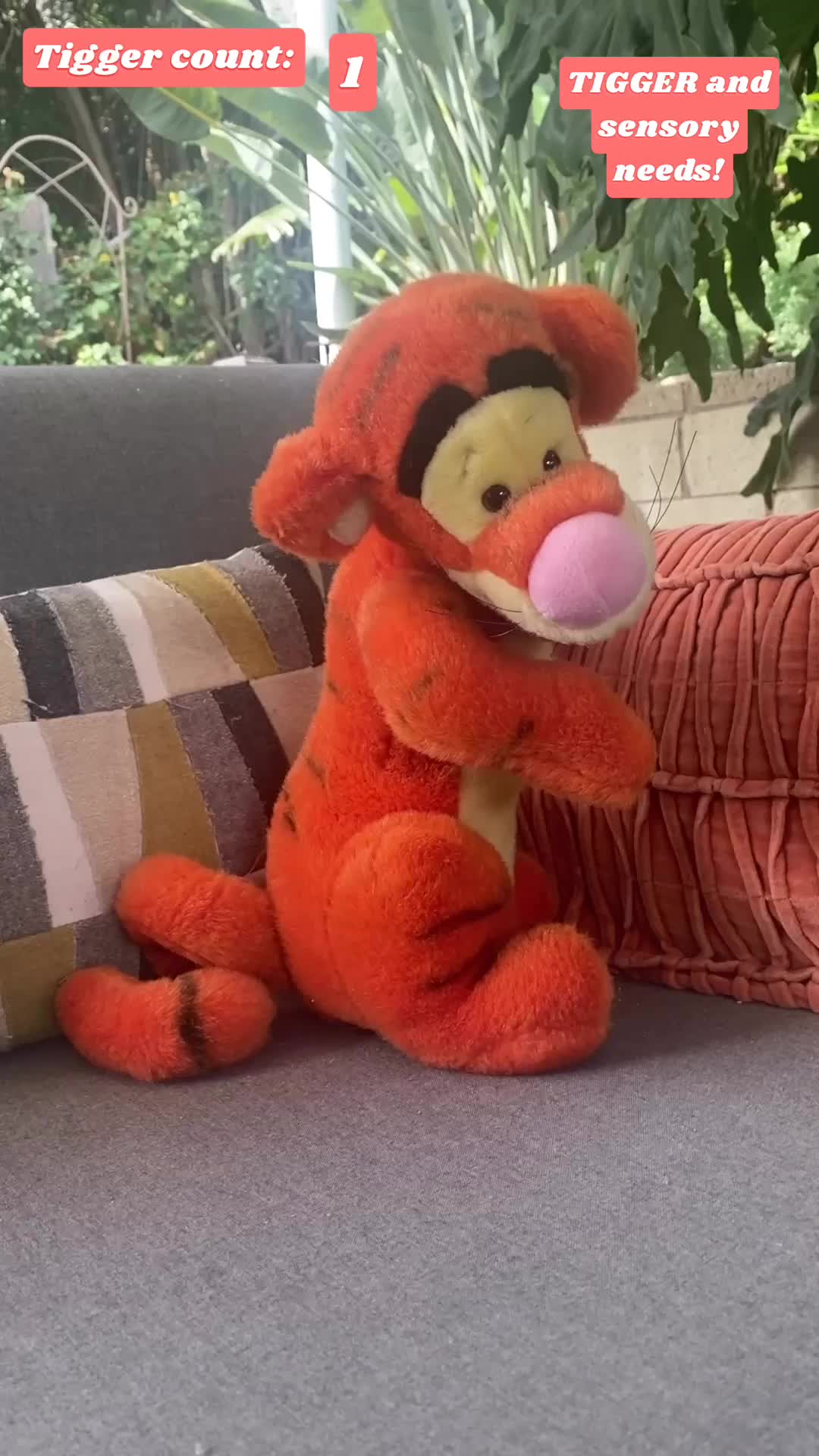 Sensory Winnie the Pooh stuffed animal sitting on a couch.