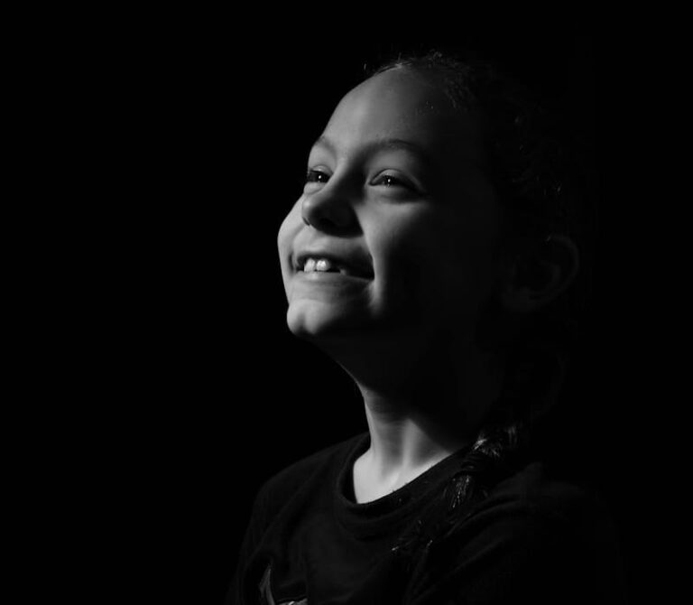 Young girl smiling looking up in black and white