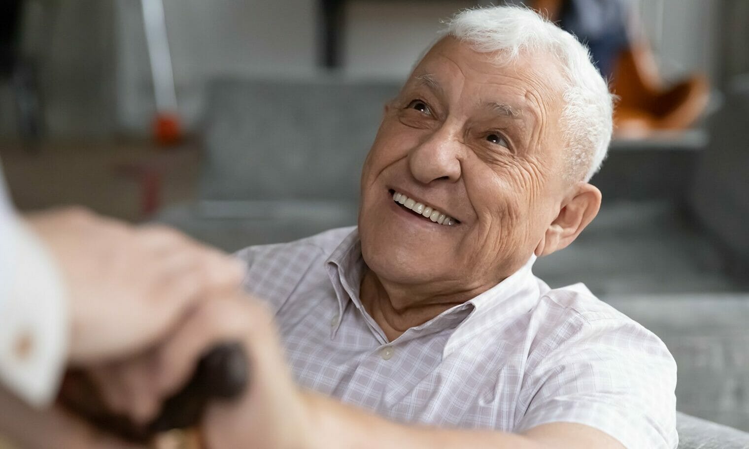 smiling old man hand on cane handle curaJOY